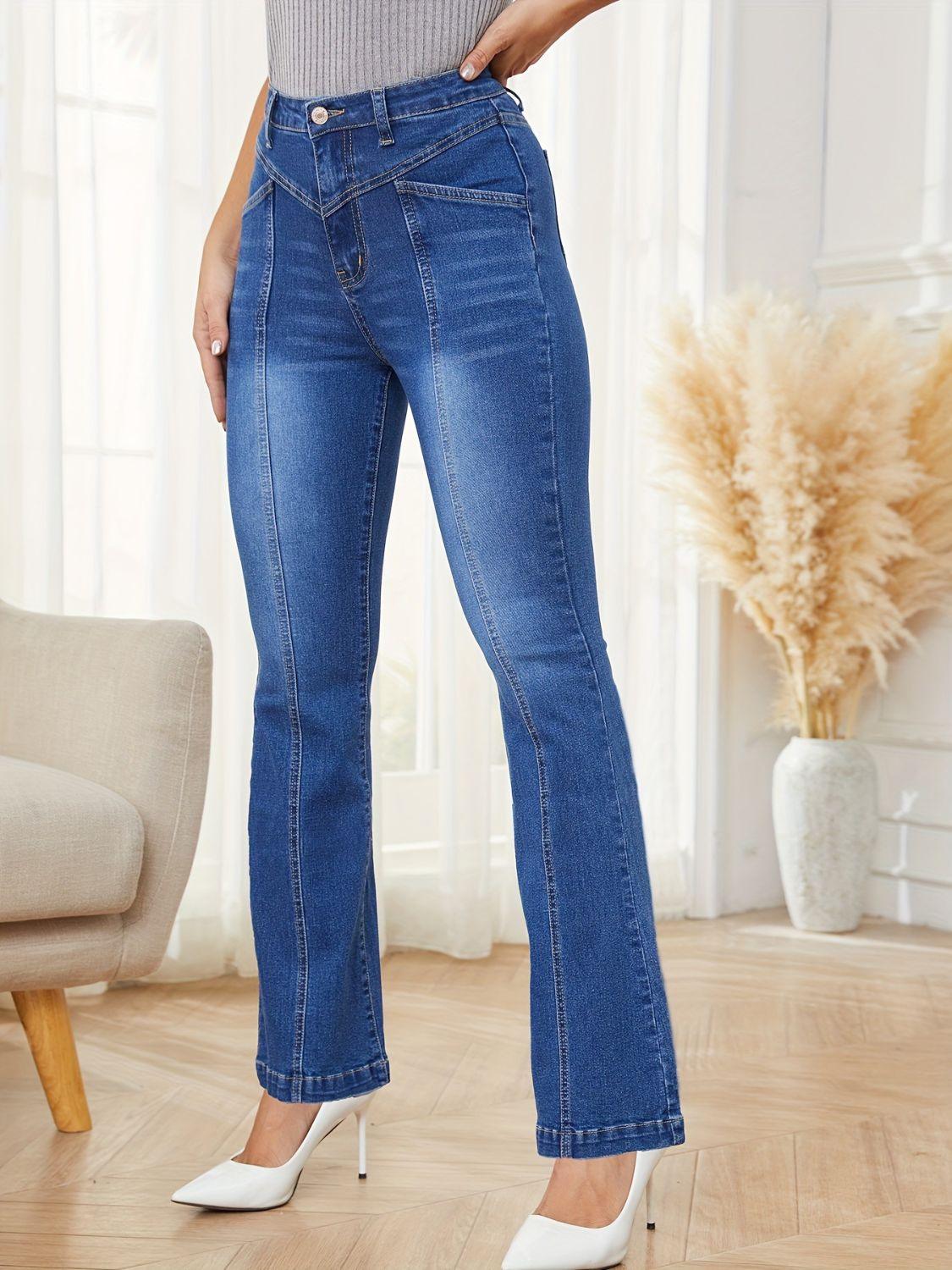 a woman standing in a room wearing a pair of jeans