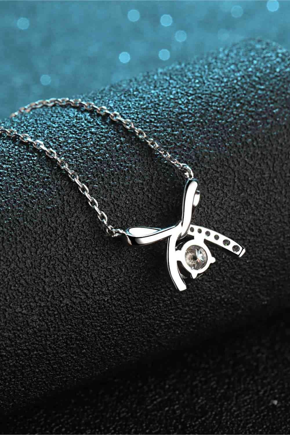 a silver necklace with a cat on it