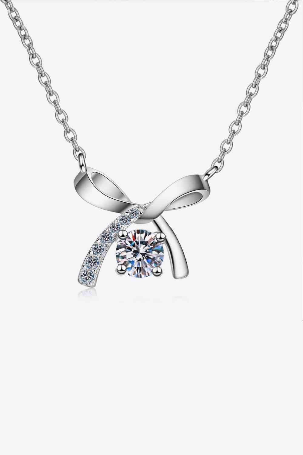 a necklace with a bow and a diamond