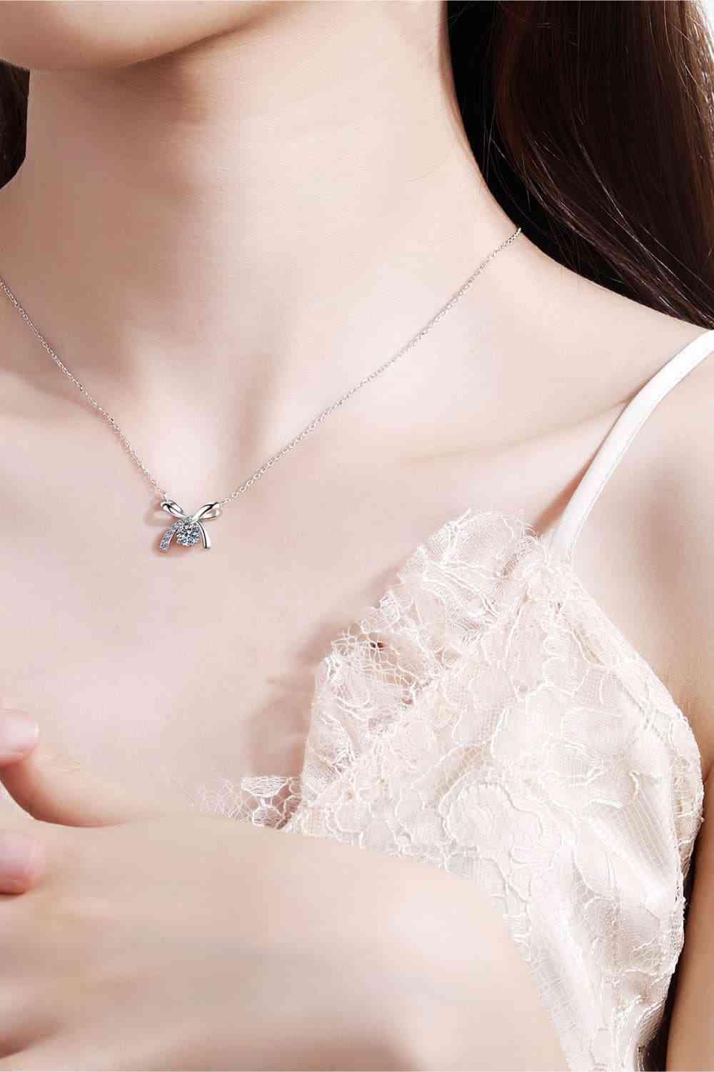 a woman wearing a necklace with a butterfly on it