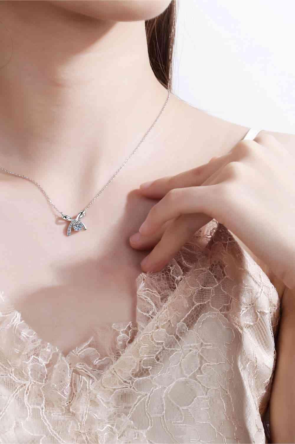 a woman wearing a necklace with a butterfly on it