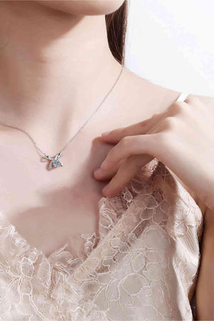 a woman wearing a necklace with a butterfly on it