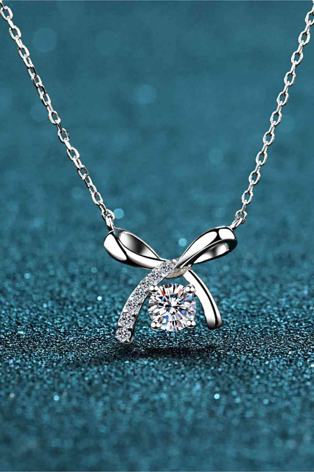 a diamond necklace with a bow on it
