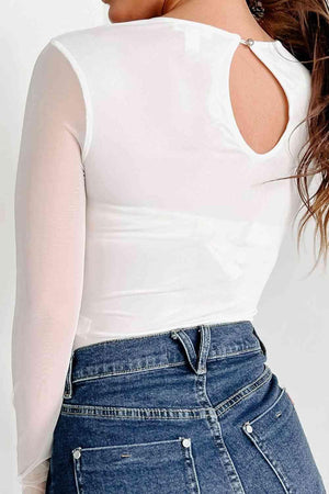 a woman wearing a white top and jeans