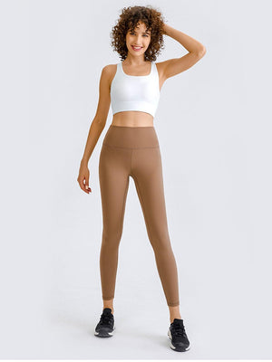 a woman in a white top and brown leggings