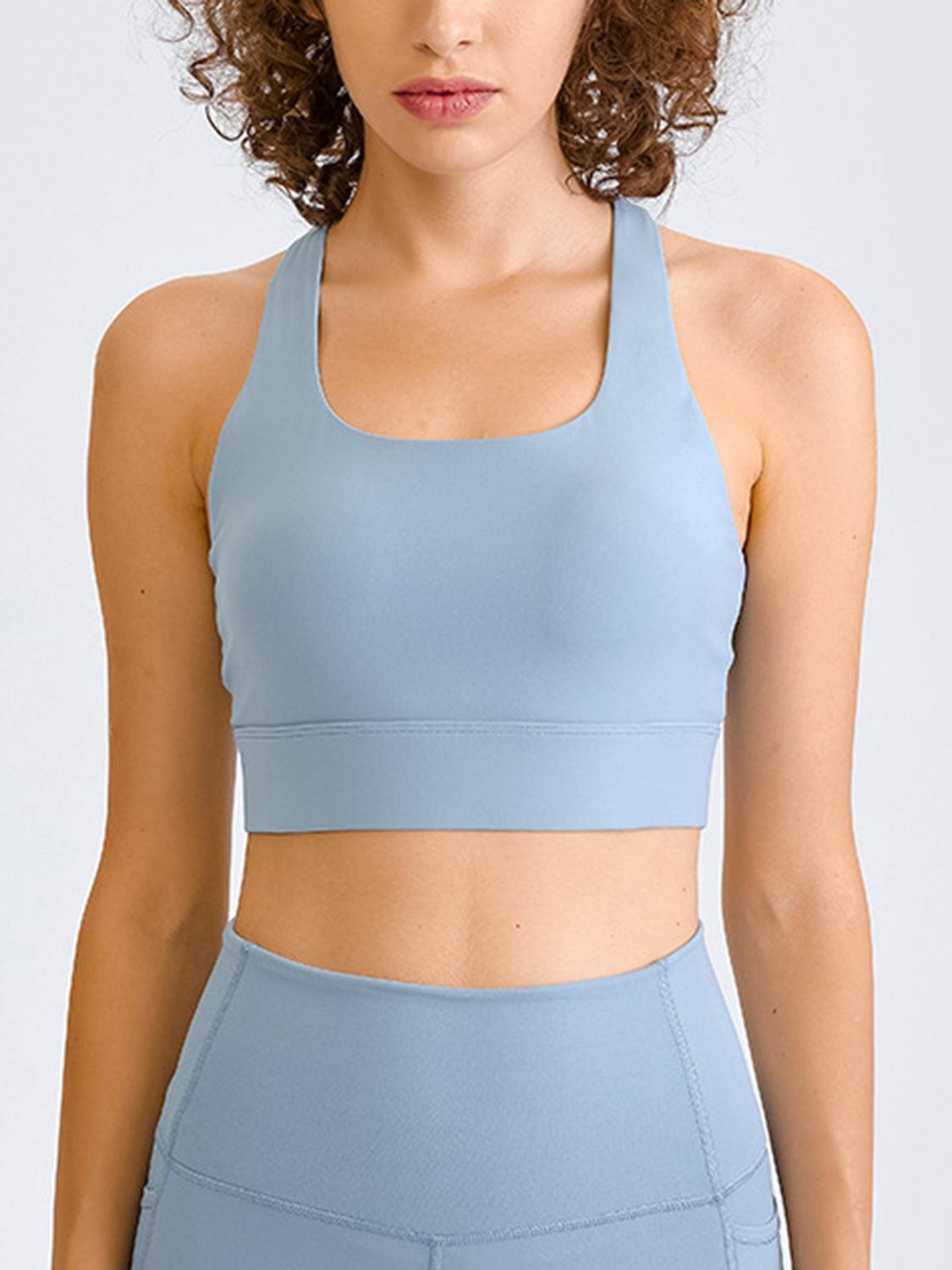 a woman with curly hair wearing a blue sports bra