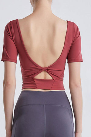 a woman wearing a red top with a cross back