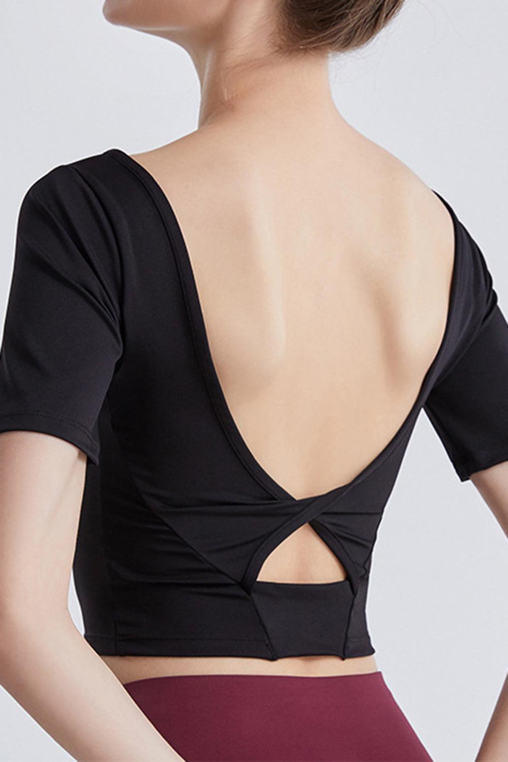 a woman wearing a black top with a cut out back