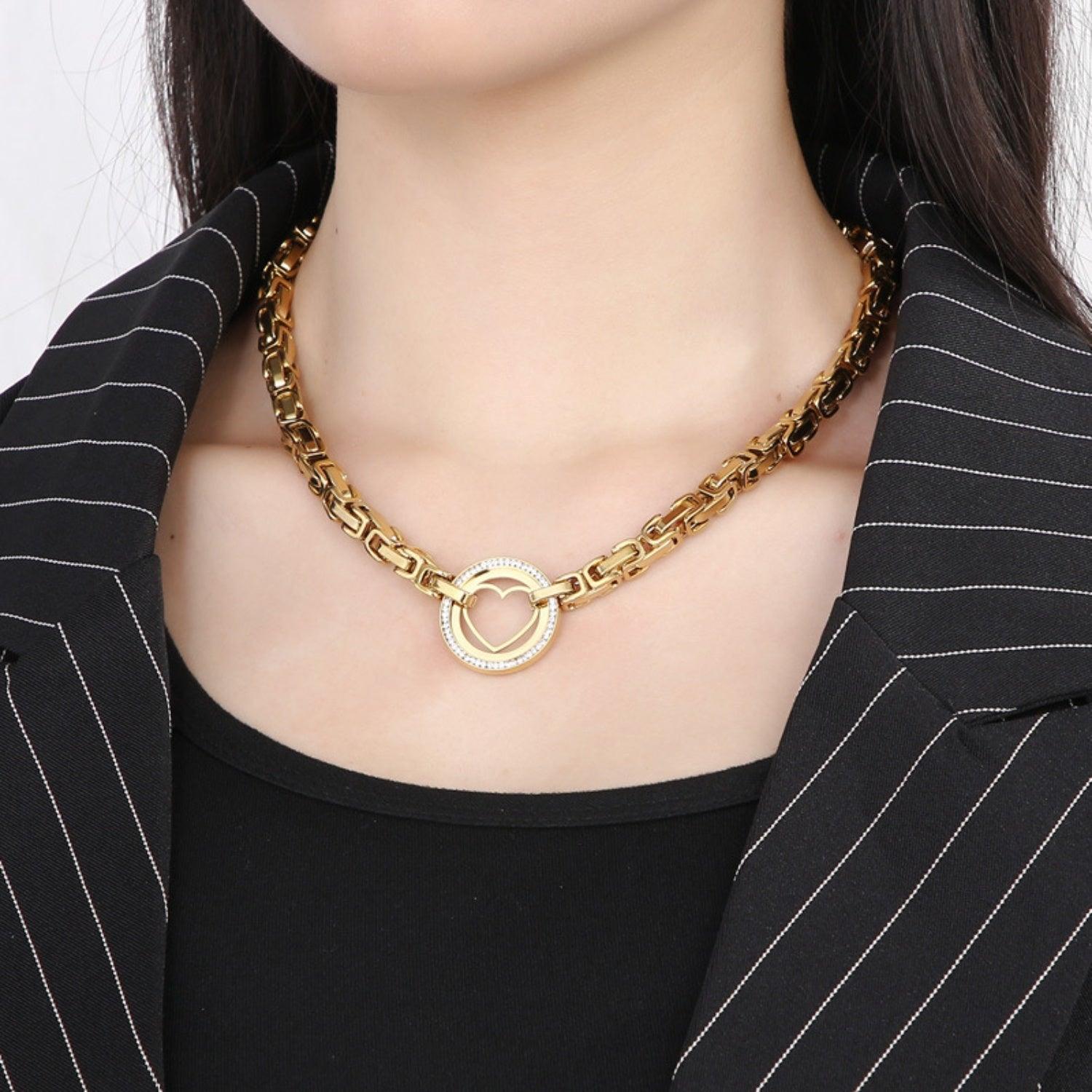 a woman wearing a black and white striped jacket and a gold chain necklace