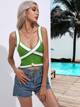 a woman standing next to a pool wearing a green and white top