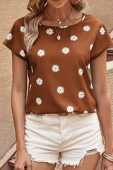 a woman wearing a brown top with white flowers on it