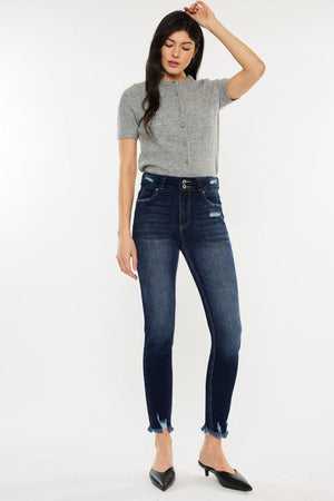 a woman in grey shirt and jeans posing for a picture