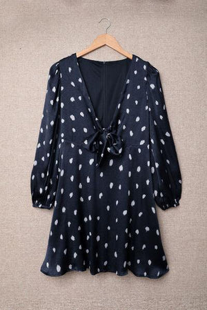 a black and white polka dot blouse hanging on a hanger