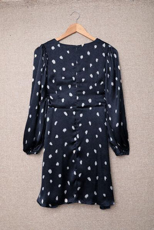 a black and white polka dot dress hanging on a hanger