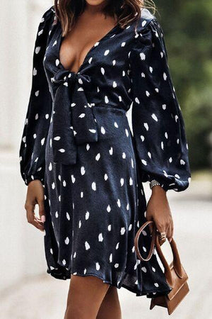 a woman wearing a black and white polka dot dress