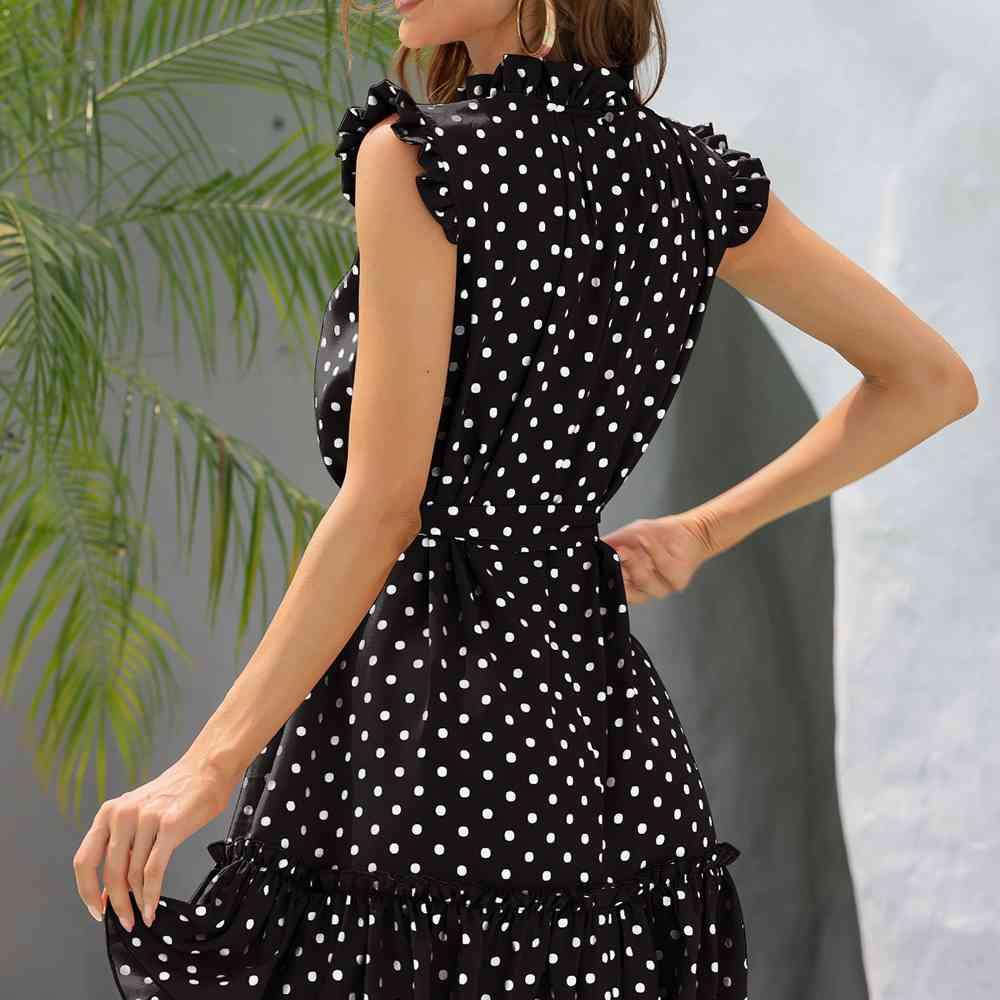 a woman wearing a black and white polka dot dress