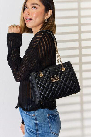 a woman is holding a black handbag