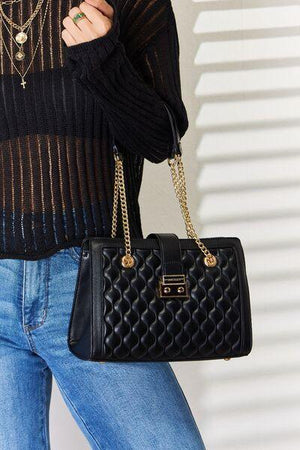 a woman wearing a black sweater and jeans holding a black purse