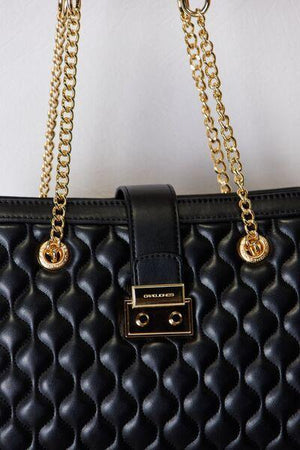 a black purse with a gold chain hanging from it