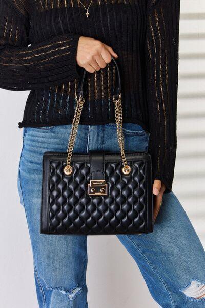 a woman is holding a black purse