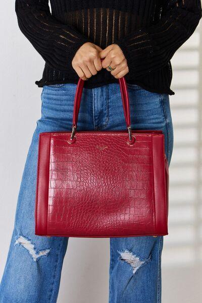 a woman is holding a red bag in her hands
