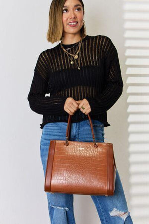 a woman is holding a brown purse and smiling