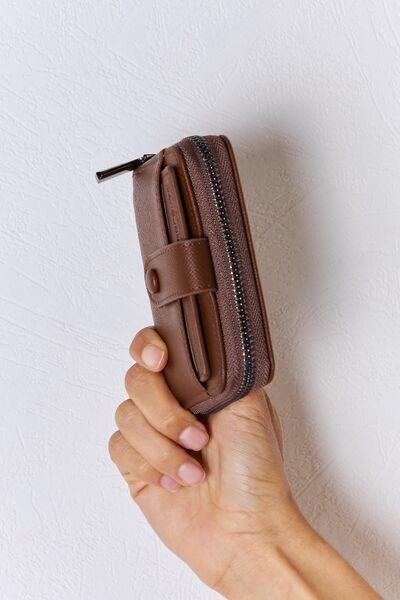 a person holding a brown wallet in their hand