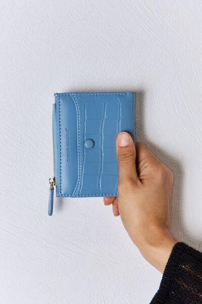 a person holding a blue wallet in their hand