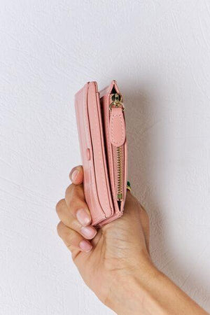 a person holding a pink purse in their hand