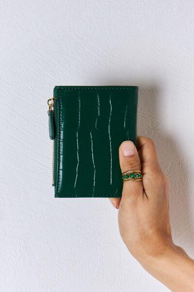 a person holding a green wallet in their hand