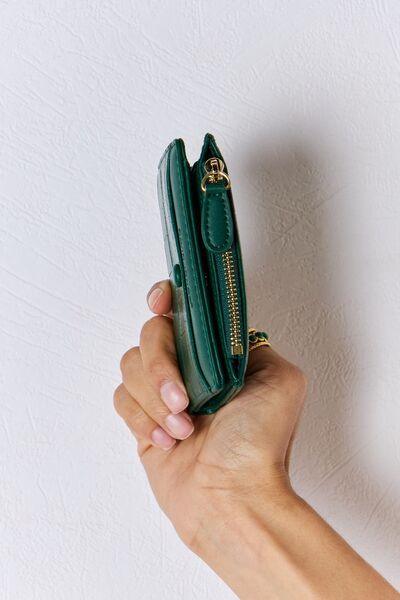 a person holding a green purse in their hand