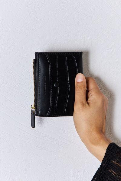 a person holding a black wallet in their hand