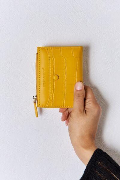 a person holding a yellow wallet in their hand