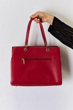 a person holding a red purse in their hand