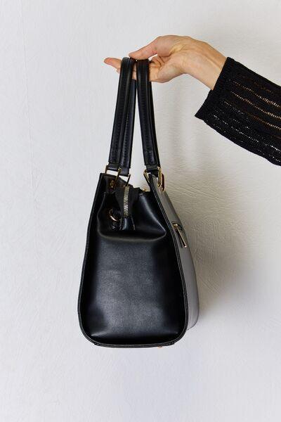 a person holding a black purse in their hand