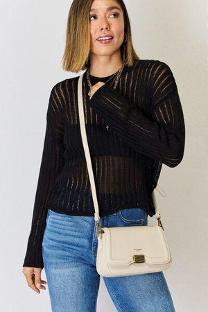 a woman in a black top is holding a white purse