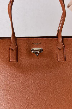 a brown handbag with a small triangle on the front