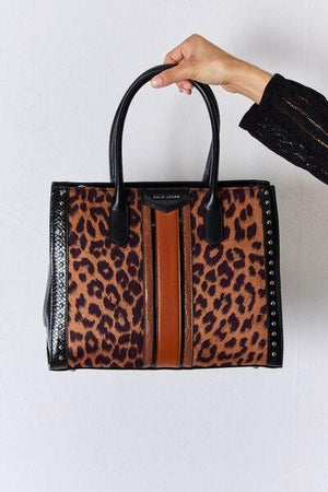 a hand holding a leopard print purse