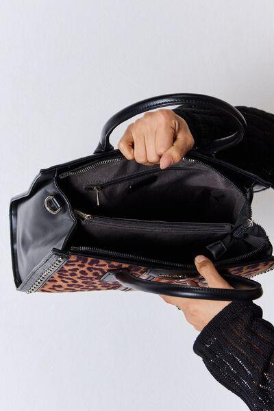 a person holding a black purse with a leopard print lining