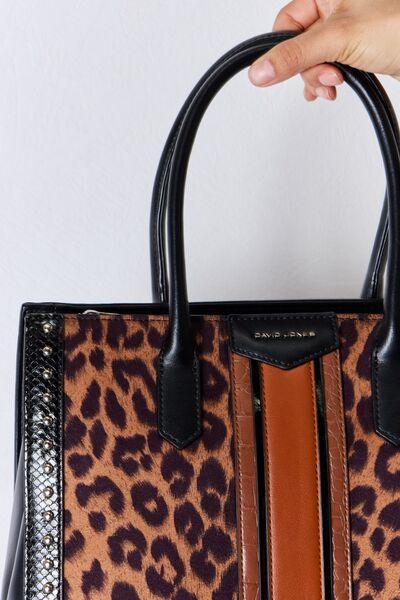 a hand holding a leopard print purse