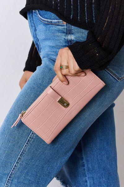 a woman is holding a pink purse