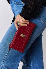 a woman in jeans and a black sweater holding a red purse