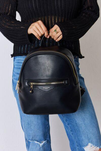 a woman is holding a black leather backpack