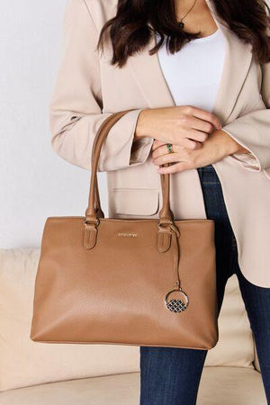 a woman is holding a tan purse
