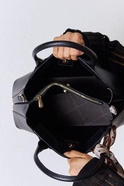 a woman is holding a black purse