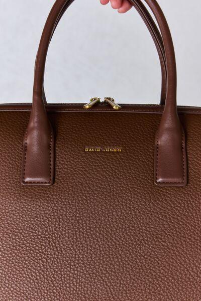 a hand is holding a brown leather bag