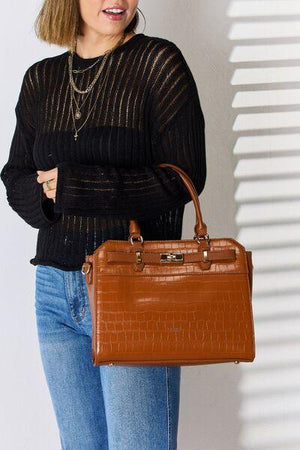 a woman is holding a brown purse