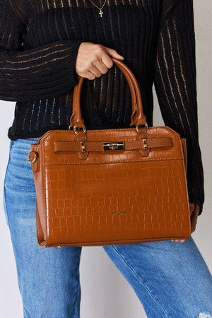 a woman is holding a brown handbag