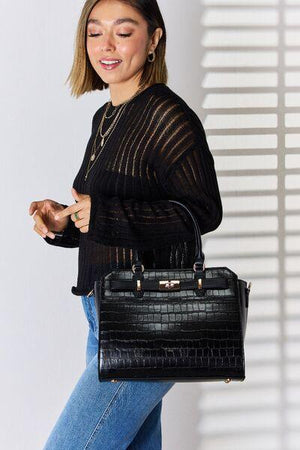 a woman is holding a black handbag