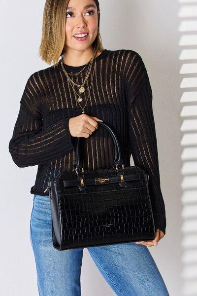 a woman is holding a black handbag
